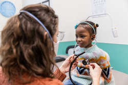 Child being examined by a woman with a stethoscope