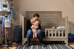 Photo of a mother hugging her ventilated child